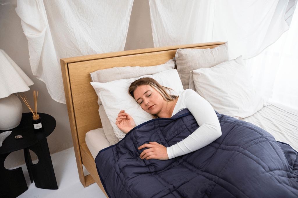 sleeping, rest, indoors, mood, calm, navy blue, weighted blanket, blanket, relaxation, comfort, sleep, anxiety relief, deep pressure stimulation, sleep aid, therapeutic, cozy, soft, textured, restful, bedroom, bedding, self-care, bedsheets, pillow, organic cotton, sleep, sleep, sleep, sleep, sleep